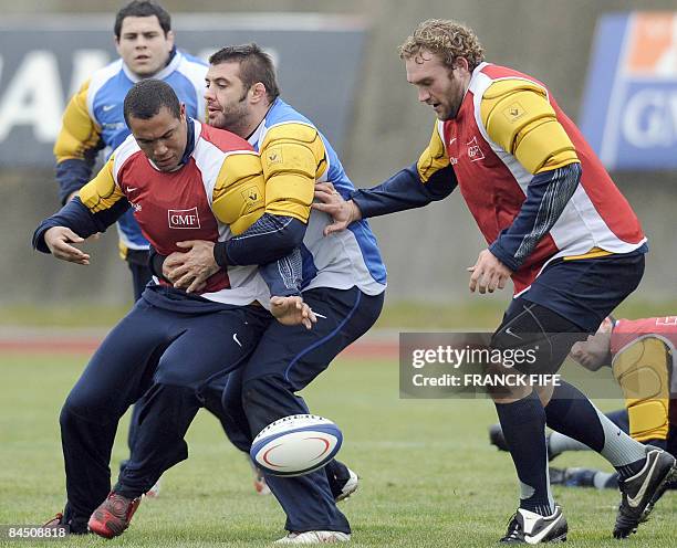France's Rugby Union national team's flanker Thierry Dusautoir vies with prop Lionel Faure and lock Romain Millo-Chlusky during a training session,...