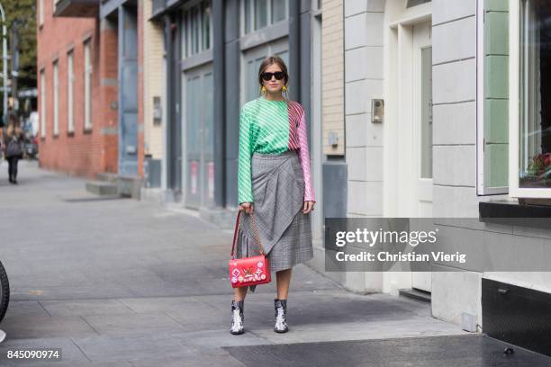 Darja Barannik wearing checked skirt, striped top, red Louis Vuitton bag, scarf in her hair seen in the streets of Manhattan outside Tibi during New...