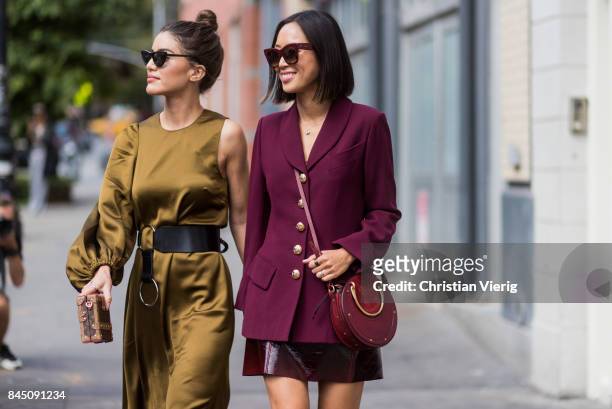Camila Coelho and Aimee Song wearing bordeaux blazer jacket, skirt, boots seen in the streets of Manhattan outside Tibi during New York Fashion Week...