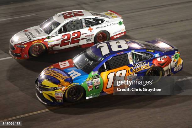 Kyle Busch, driver of the M&M's Caramel Toyota, races Joey Logano, driver of the Shell Pennzoil/Red Cross Ford, during the Monster Energy NASCAR Cup...