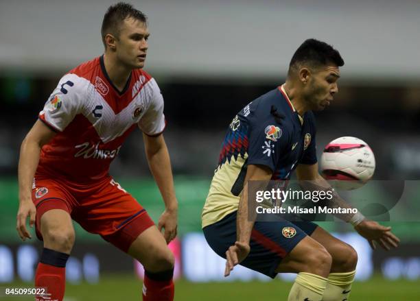 Silvio Romero of America controls the ball under the pressure of Kristian Alvarez of Veracruz during the 8th round match between America and Veracruz...