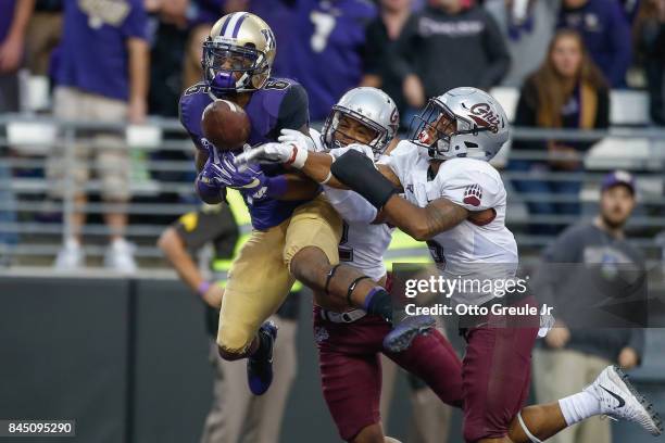 Wide receiver Chico McClatcher of the Washington Huskies has this pass batted away in the end zone by cornerback Ryan McKinley and safety Justin...