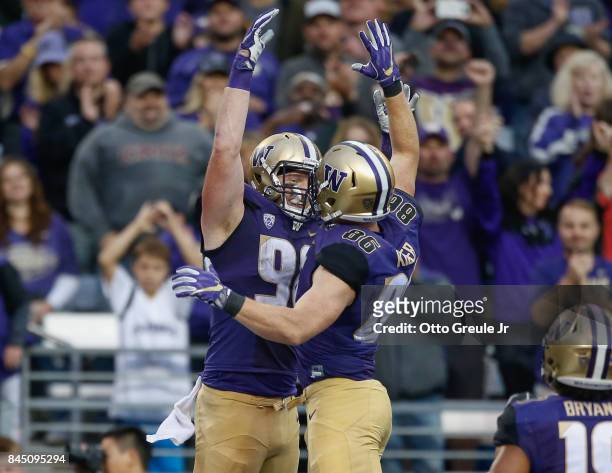 Tight end Will Dissly of the Washington Huskies is congratulated by tight end Jacob Kizer after scoring a touchdown against the Montana Grizzlies at...