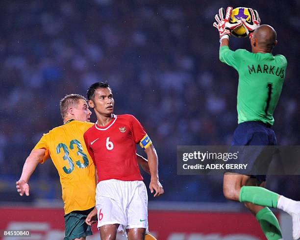 Indonesian goalkeeper Markus Horison catches the ball as Australia's Danny Allsopp and Indonesia's Charis Yulianto look on during the group B AFC...