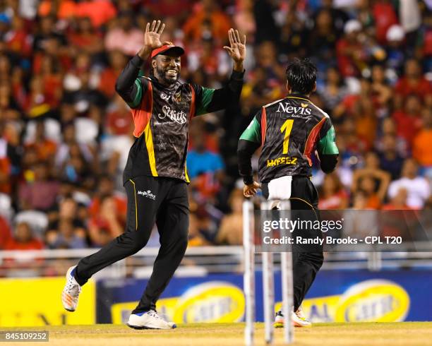 In this handout image provided by CPL T20, Chris Gayle and Mohammad Hafeez of St Kitts & Nevis Patriots celebrates the dismissal of Darren Bravo of...