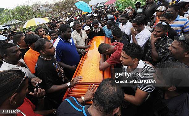 Family members mourn over the coffin of ethnic Indian Ananthan Kugan during the burial ceremony in Puchong outside Kuala Lumpur on January 28, 2009....
