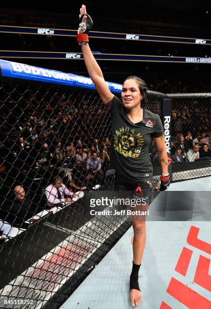 Amanda Nunes of Brazil raises her hand after facing Valentina Shevchenko of Kyrgyzstan in their women's bantamweight bout during the UFC 215 event...