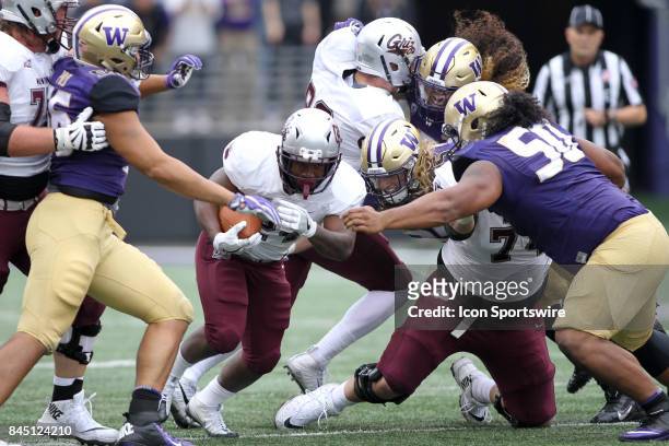 Washington's Jared Pulu , Ben Burr-Kirven and Vita Vea mov in to tackle Montana Alijah Lee at the end of a run during a college football game between...