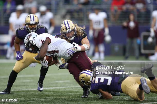 Washington's Ben Burr-Kirven Center, Isaiah Gilchrist Right and Sean Constantine wrap up Montana's Alijah Lee at the end of a run during a college...