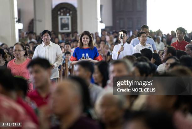 Ferdinand "Bongbong" Marcos Jnr , former senator and son of the late dictator Ferdinand Marcos, and his sister Imee attend a mass at the Immaculate...