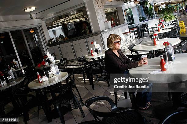 Shannon LeDuc from Alberta, Canada drinks a cup of coffee at a restaurant on the famed Ocean Drive strip on January 28, 2009 in Miami Beach, Florida....