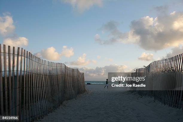 Joggers dot the beach near the famed Ocean Drive strip on January 28, 2009 in Miami Beach, Florida. As the economic downturn continues the number of...