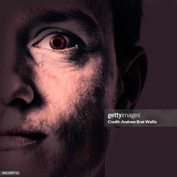close up of an evil male face appearing out of darkness - psychopath stock pictures, royalty-free photos & images