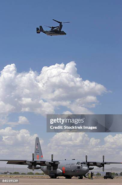 a cv-22 osprey flies over a c-130 hercules aircraft. - rotor basculante fotografías e imágenes de stock