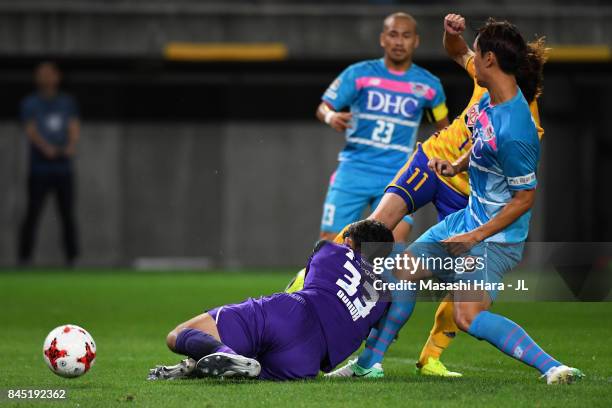 Naoki Ishihara of Vegalta Sendai scores the opening goal while Shuichi Gonda of Sagan Tosu gets injured during the J.League J1 match between Vegalta...