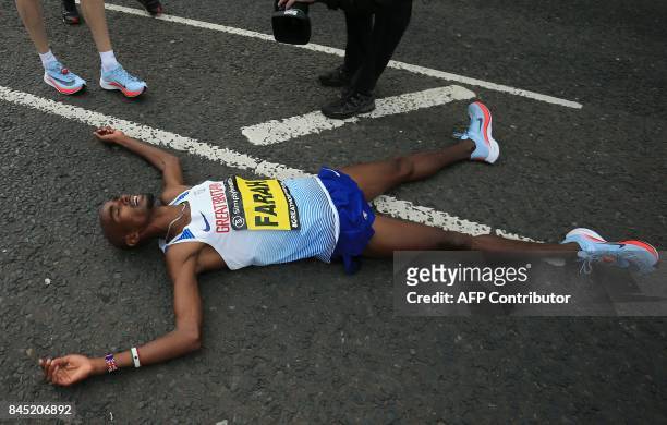 Britain's Mo Farah lies on the road after winning the men's elite race of the Great North Run half-marathon in South Shields, north east England on...