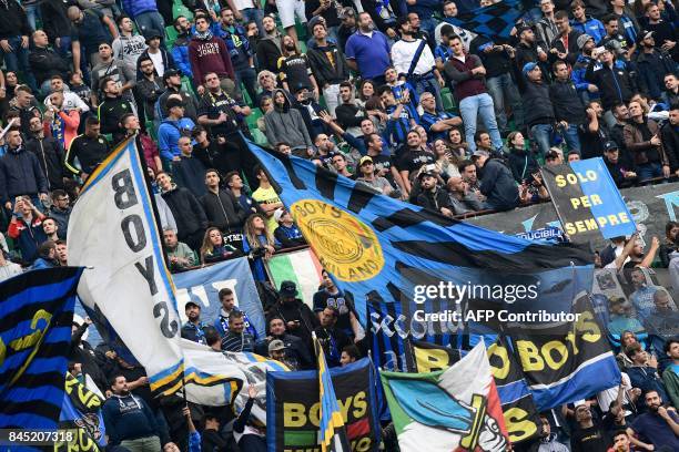 Inter Milan fans hold flags during the Italian Serie A football match between Inter Milan and Spal at San Siro Stadium in Milan on September 10,...