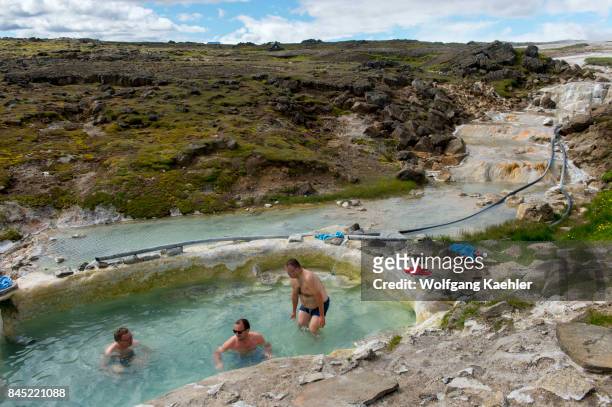 People are bathing in a pool fed by hot springs at Hveravellir, a geothermal area of fumaroles, and multicolored hot pools in the central highlands...
