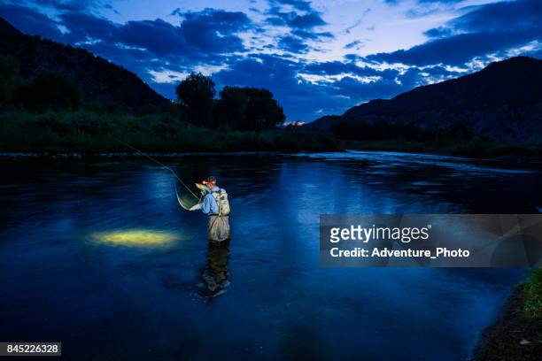 fly fishing en el río de noche con linterna - río eagle fotografías e imágenes de stock