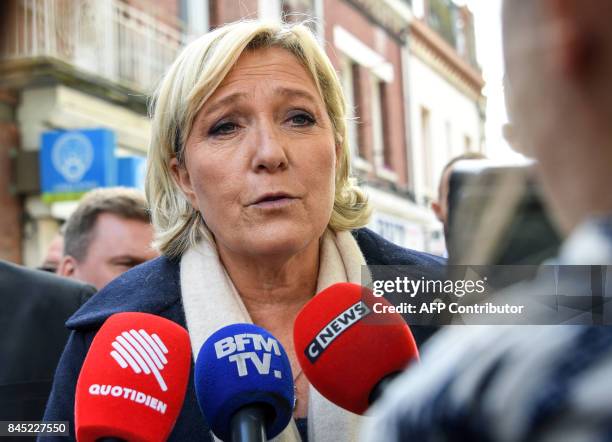 French far-right Front National President and Member of Parliament Marine Le Pen speaks to the press as she walks in the streets of Henin-Beaumont,...