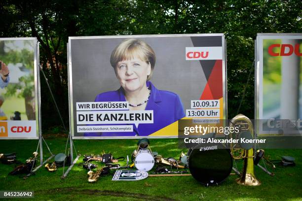 Traditional instruments stand in front of a billboard of German Chancellor and Christian Democrat Angela Merkel prior her speech to supporters at a...