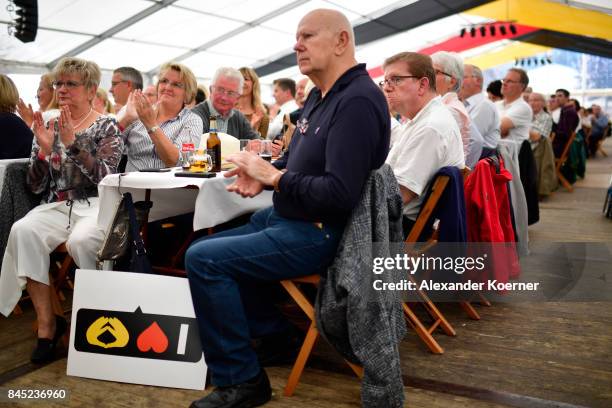 Supporters of German Chancellor and Christian Democrat Angela Merkel listen to her speech at a fest tent during an election campaign stop on...