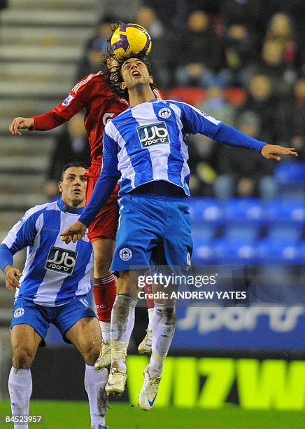 Wigan Athletic's Egyptian forward Mido wins a header from Liverpool's Brazilian midfielder Lucas during the English Premier league football match at...