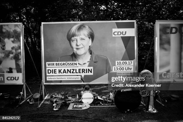 Traditional instruments stand in front of a billboard of German Chancellor and Christian Democrat Angela Merkel prior her speech to supporters at a...
