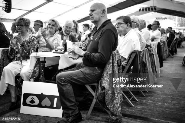 Supporters of German Chancellor and Christian Democrat Angela Merkel listen to her speech at a fest tent during an election campaign stop on...