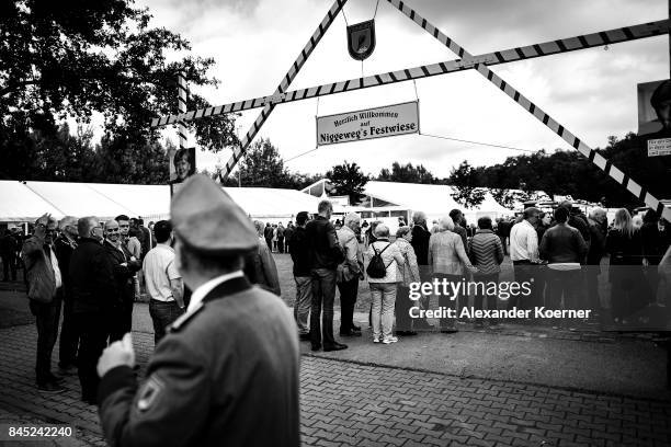 Supporters of German Chancellor and Christian Democrat Angela Merkel stand in line prior a speech to supporters at a fest tent during an election...