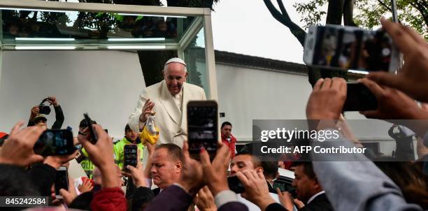 Pope Francis waves from the popemobile as he leaves the nunciature for the CATAM military airport on his way to Cartagena, on September 10 in Bogota...