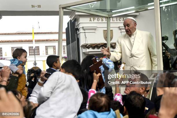 Pope Francis waves from the popemobile as he leaves the nunciature for the CATAM military airport on his way to Cartagena, on September 10 in Bogota...