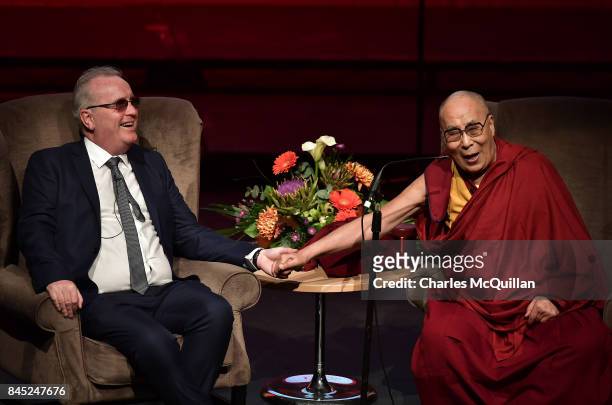 His Holiness The Dalai Lama holds the hand of Richard Moore as he gives a public talk on the theme of 'Compassion in Action' to celebrate 20 years of...