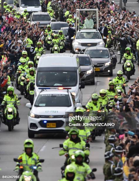 Pope Francis waves from the popemobile as he leaves the nunciature for the CATAM military airport on his way to Cartagena, on September 10 in Bogota...