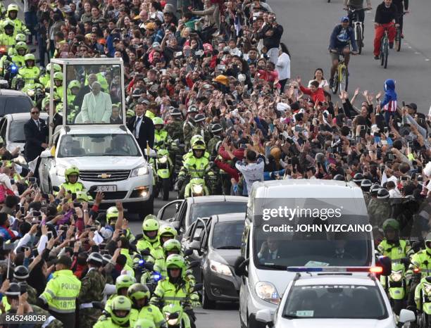 Pope Francis waves from the popemobile as he leaves the nunciature for the CATAM military airport on his way to Cartagena, on September 10 in Bogota...