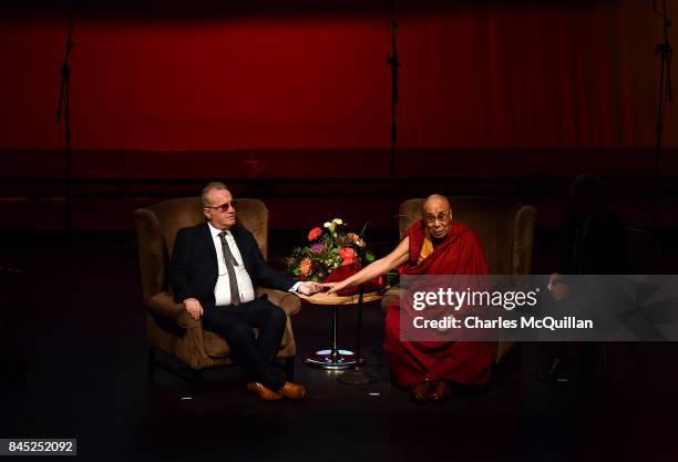 His Holiness The Dalai Lama holds the hand of Richard Moore as he gives a public talk on the theme of 'Compassion in Action' to celebrate 20 years of...