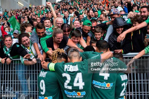 Saint-Etienne's players celebrate with fans after opening the scoring during the French L1 football match between Saint-Etienne and Angers on...
