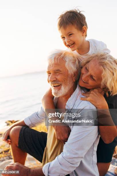 verano con los abuelos - grandmother and grandchild beach fotografías e imágenes de stock