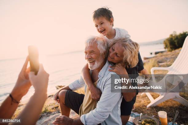 captura de nuestros momentos de picnic - grandmother and grandchild beach fotografías e imágenes de stock