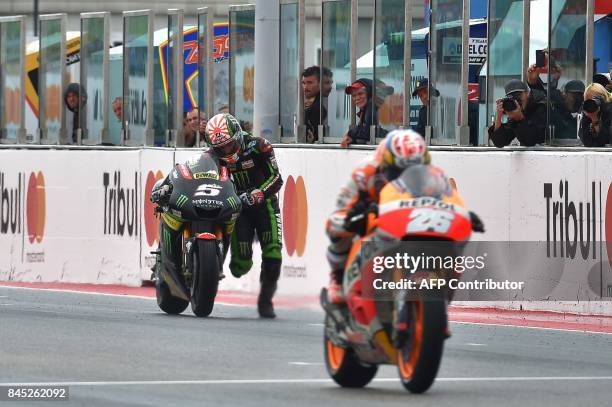 Monster Yamaha Team's French rider Johann Zarco pushes his bike across the finish line during the San Marino Moto GP Grand Prix at the Marco...