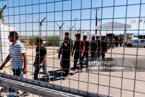 Syrian refugees queue as they arrive at the Kokkinotrimithia refugee camp, some 20 kilometres outside the Cypriot capital Nicosia, on September 10...