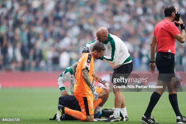 Johan Wiland, goalkeeper of Hammarby IF is getting medical attention during the Allsvenskan match between Hammarby IF and AIK at Tele2 Arena on...