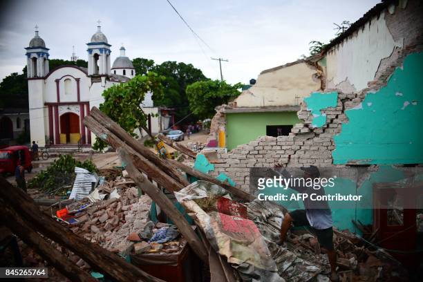 Local residents search for belongings amid the ruins of their home, knocked down by Thursday night's 8.2-magnitude quake, in Juchitan, Oaxaca,...