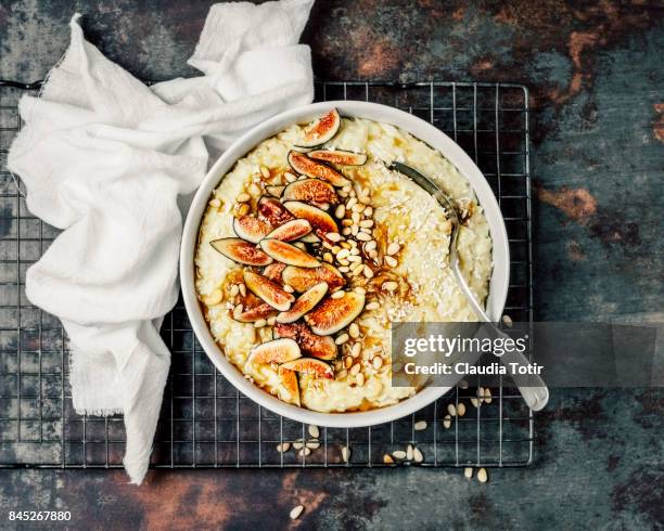 rice pudding with pine nuts, fresh figs and maple syrup - rice pudding stock pictures, royalty-free photos & images