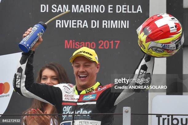 Kiefer Racing Team's Swiss rider Dominique Aegerter celebrates on the podium after winning the San Marino Moto2 Grand Prix at the Marco Simoncelli...