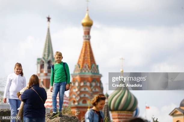 Russian people visit Moscow's new park at the Zaryadye Park with St Basil's Cathedral in the background in Moscow, Russia, on September 10, 2017.