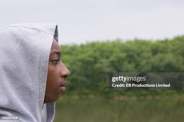 profile of african boy in hoody sweatshirt - afrikanisches kind beobachtet natur stock-fotos und bilder