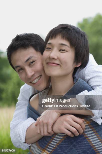 asian couple hugging outdoors - joue contre joue photos et images de collection