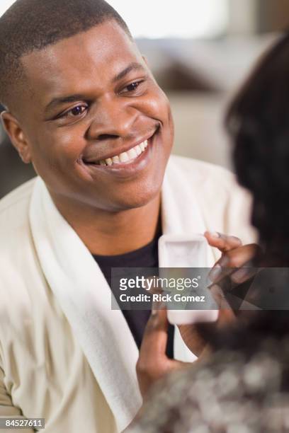 african man giving girlfriend engagement ring - esperanza gomez fotografías e imágenes de stock