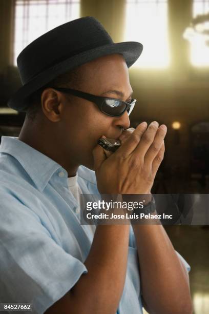 african man in hat and sunglasses playing harmonica - harmonica stock pictures, royalty-free photos & images